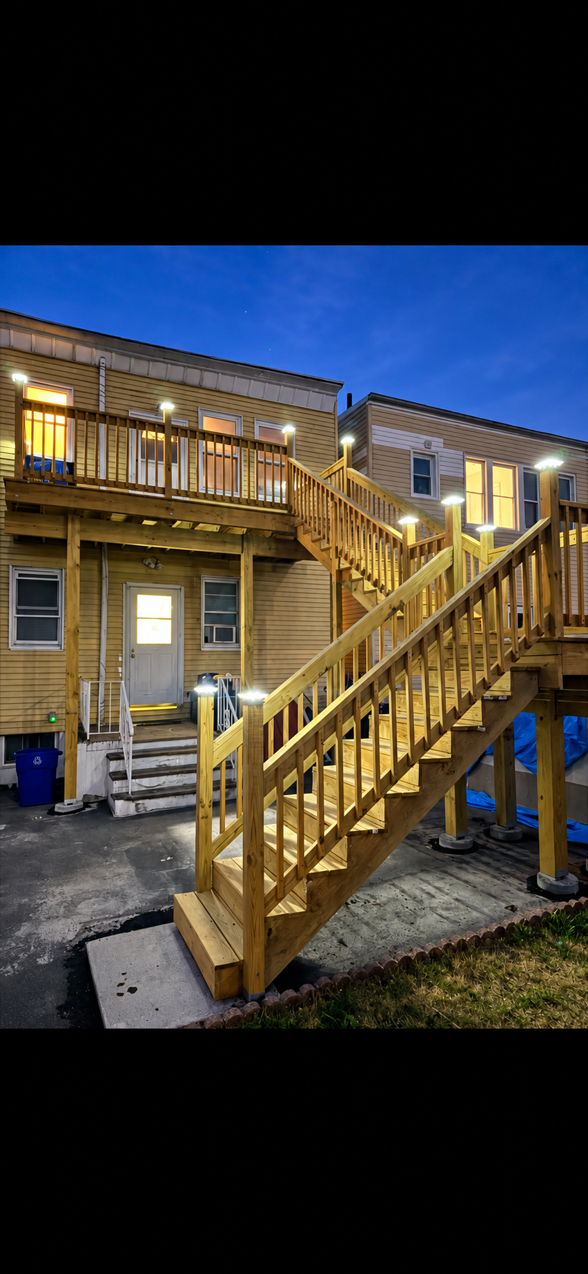 Completed wood deck and illuminated exterior staircase by EastCoast Renovations